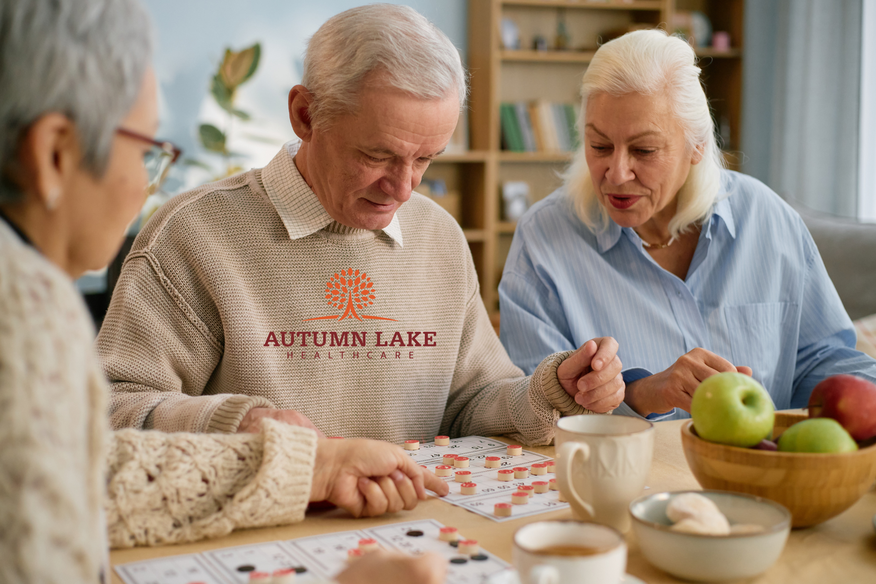 Seniors at a nursing home playing a board game together at a table.